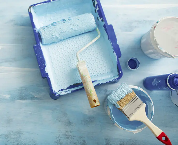 Painter loading a brush from a can of Amazon Paint