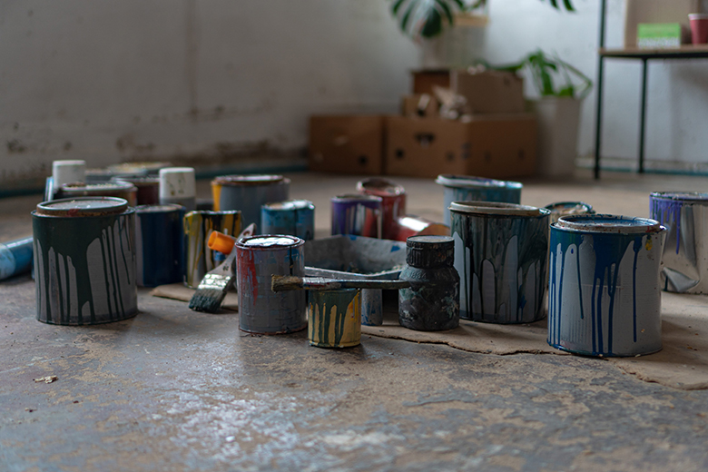 Open cans of colored paint on a workbench
